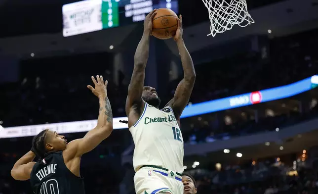 Milwaukee Bucks forward Taurean Prince (12) goes up to dunk in the first half of an NBA basketball game against the Brooklyn Nets, Friday, April 10, 2026, in Milwaukee. (AP Photo/Jeffrey Phelps)