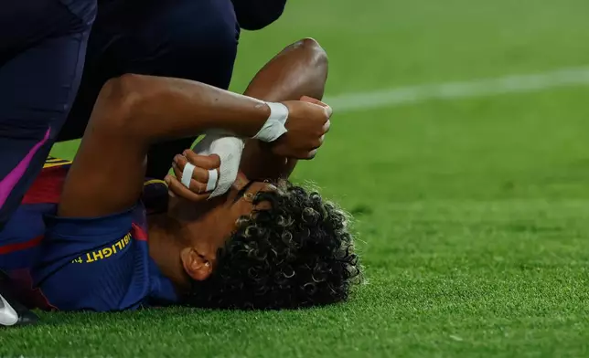 Barcelona's Lamine Yamal lies on the pitch injured during the Spanish La Liga soccer match between Barcelona and Celta Vigo in Barcelona, Spain, Wednesday, April 22, 2026. (AP Photo/Joan Monfort)