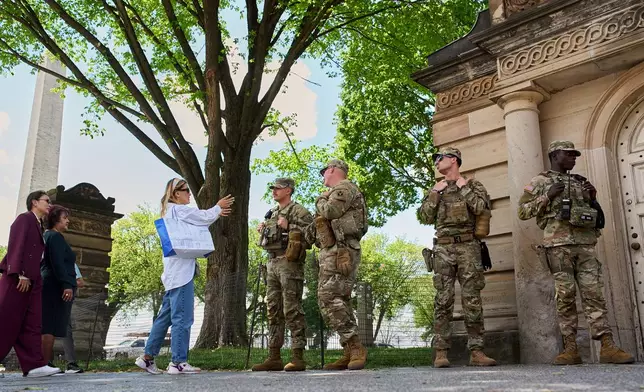 A tourist asks members of the Florida National Guard for directions on the National Mall, across from the Washington Monument, Friday April 17, 2026, in Washington. (AP Photo/Jacquelyn Martin)