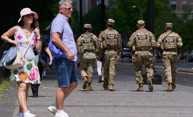 Members of the Florida National Guard pass by tourists on a sidewalk Friday April 17, 2026, in Washington. (AP Photo/Jacquelyn Martin)