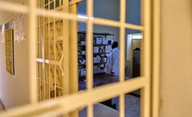 A staffer checks the pharmacy shelves at a public health clinic in Qoz Nafisa village, Khartoum state, Sudan, Wednesday, April 22, 2026. (AP Photo/Bernat Armangue)