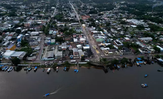 A boat maneuvers near the city of Oiapoque, Brazil, and its ports on the banks of the Oiapoque River, Tuesday, March 10, 2026. (AP Photo/Eraldo Peres)