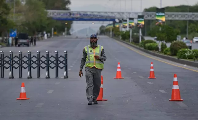 A police officer stands to divert traffic on a road barricaded by authorities due to security arrangements for possible second round of talks between the U.S. and Iran, in Islamabad, Pakistan, Friday, April 24, 2026. (AP Photo/M.A. Sheikh)