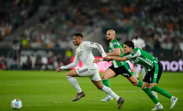 Betis' Marc Bertra holds Real Madrid's Kylian Mbappe during a La Liga soccer match between Real Betis and Real Madrid in Seville, Spain, Friday, April 24, 2026. (AP Photo/Jose Breton)