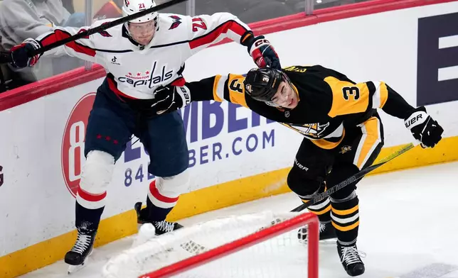 Washington Capitals' Aliaksei Protas (21) is defended by Pittsburgh Penguins' Jack St. Ivany during the first period of an NHL hockey game in Pittsburgh, Saturday, April 11, 2026. (AP Photo/Gene J. Puskar)