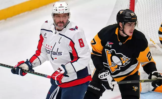 Washington Capitals' Alex Ovechkin (8) is defended by Pittsburgh Penguins' Ryan Graves (27) during the first period of an NHL hockey game in Pittsburgh, Saturday, April 11, 2026. (AP Photo/Gene J. Puskar)