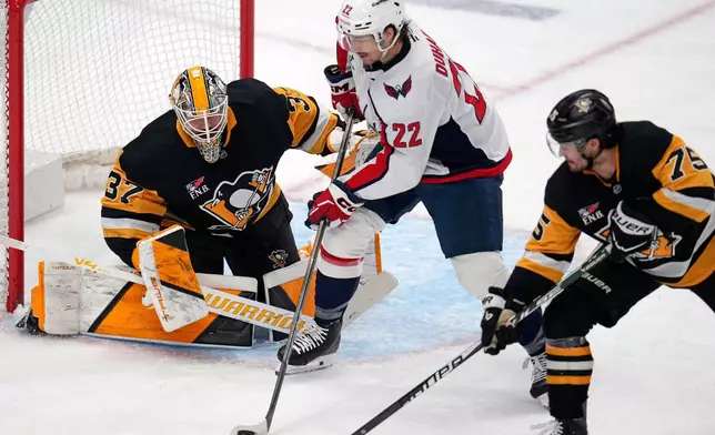 Washington Capitals' Brandon Duhaime (22) can't get off a shot in front of Pittsburgh Penguins goaltender Arturs Silovs (37) with Connor Clifton (75) defending during the first period of an NHL hockey game in Pittsburgh, Saturday, April 11, 2026. (AP Photo/Gene J. Puskar)