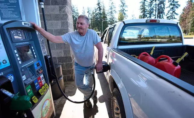 Darryl Smith fuels up his truck after putting extra gasoline into cans at the Tulalip Market gas station on the Tulalip Indian Reservation land, Wednesday, April 8, 2026, in Tulalip, Wash. (AP Photo/Lindsey Wasson)