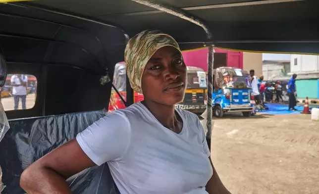 Hawa Mansaray, a rickshaw driver waits in line in Freetown, Sierra Leone, March 7, 2026. (AP Photo/Abdul Hamid Kanu)