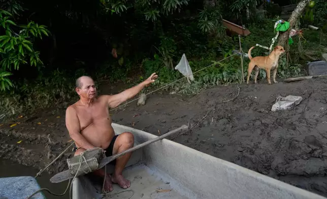 Fisherman Alvaro Molina, who lives along the banks of the Magdalena River and says he regularly encounters hippos descended from animals once kept by drug trafficker Pablo Escobar, sits in his boat in Puerto Triunfo, Colombia, Thursday, April 23, 2026. (AP Photo/Fernando Vergara)