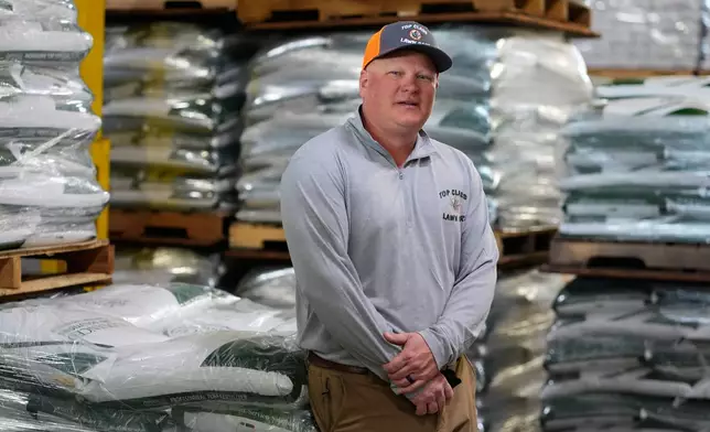 Top Class Lawn Care owner Jake Wilson stands by fertilizer he stockpiled at his supplier's warehouse in anticipation of Iran war related price hikes Thursday, March 26, 2026, in Riverside, Mo. (AP Photo/Charlie Riedel)