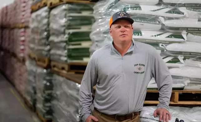 Top Class Lawn Care owner Jake Wilson stands by fertilizer he stockpiled at his supplier's warehouse in anticipation of Iran war related price hikes Thursday, March 26, 2026, in Riverside, Mo. (AP Photo/Charlie Riedel)