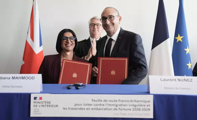 Britain's Home Secretary Shabana Mahmood, left, signs an agreement with France's Interior Minister Laurent Nunez during her visit in Dunkirk, France, Thursday April 23, 2026. (Stefan Rousseau/Pool Photo via AP)