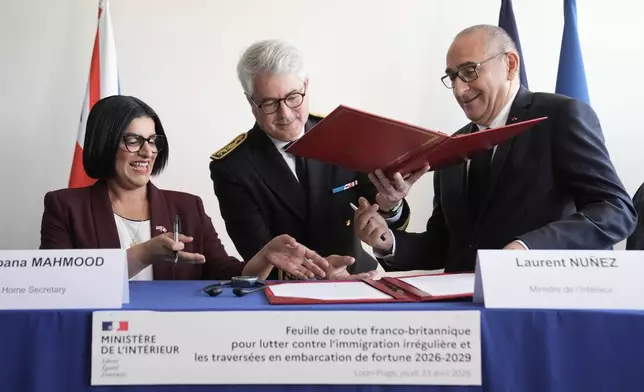 Britain's Home Secretary Shabana Mahmood, left, signs an agreement with France's Interior Minister Laurent Nunez during her visit in Dunkirk, France, Thursday April 23, 2026. (Stefan Rousseau/Pool Photo via AP)