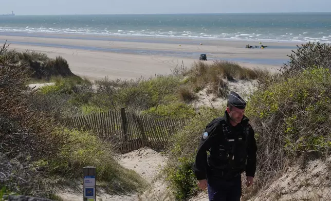 A French police officer walks on the beach of Zuydcoote, near Dunkirk, northern France, Thursday, April 23, 2026. (AP Photo/Michel Euler)