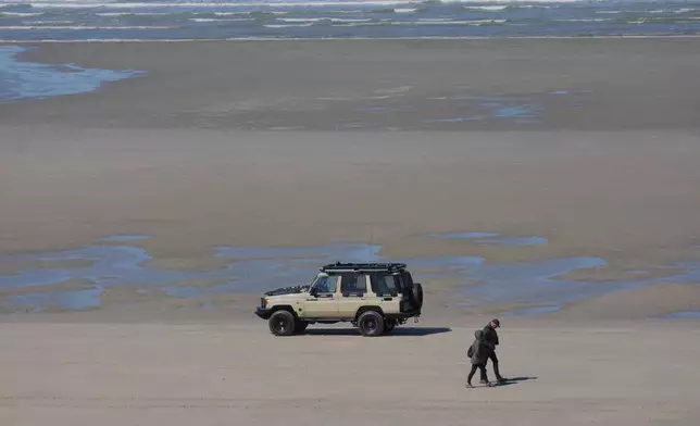A French police car patrols on the beach of Zuydcoote, near Dunkirk, northern France, Thursday, April 23, 2026. (AP Photo/Michel Euler)