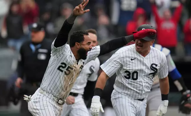 Chicago White Sox's Derek Hill (25) celebrates with Reese McGuire (30) as he scores the winning run on a walk-off single by Tristan Peters in the 10th inning of their home-opener baseball game against the Toronto Blue Jays, Friday, April 3, 2026, in Chicago. (AP Photo/Erin Hooley)