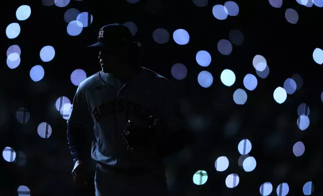 FILE - Houston Astros relief pitcher Bryan King warms up before facing the Seattle Mariners as fan turn their phone lights on during the sixth inning of a baseball game, Saturday, April 11, 2026, in Seattle. (AP Photo/Lindsey Wasson, File)