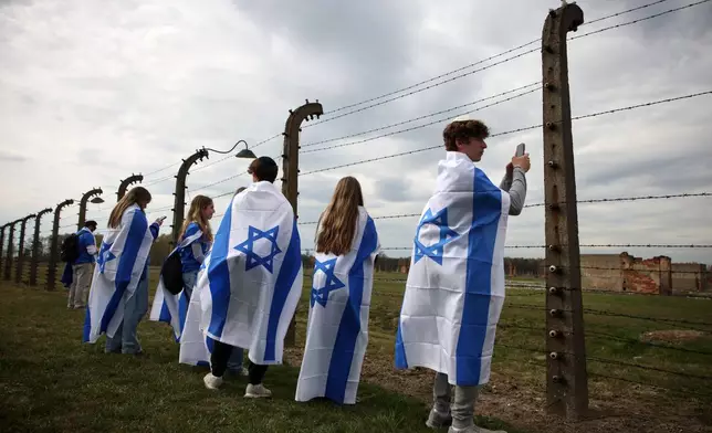 FILE - People take part in the annual "March of the Living" to commemorate the Holocaust, a yearly Holocaust remembrance march between the former death camps of Auschwitz and Birkenau, in Oswiecim, Poland, on Tuesday, April 14, 2026. (AP Photo/Beata Zawrzel, File)