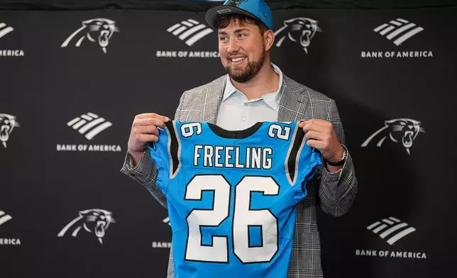 Carolina Panthers first-round draft pick Monroe Freeling holds up his jersey during an NFL football news conference, Friday, April 24, 2026, in Charlotte, N.C. (AP Photo/Matt Kelley)