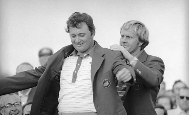 FILE - In this April 12, 1976 file photo, Jack Nicklaus, right, assists Raymond Floyd in putting on his green jacket after Floyd won the Masters Golf Championship at Augusta, Ga. (AP Photo/file)