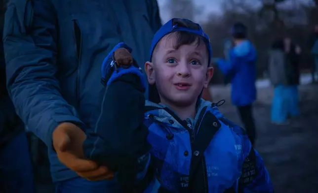 A boy releases a rescued bat during a ceremony of returning bats to the wild in Kyiv, Ukraine, Saturday, April 4, 2026. (AP Photo/Dan Bashakov)