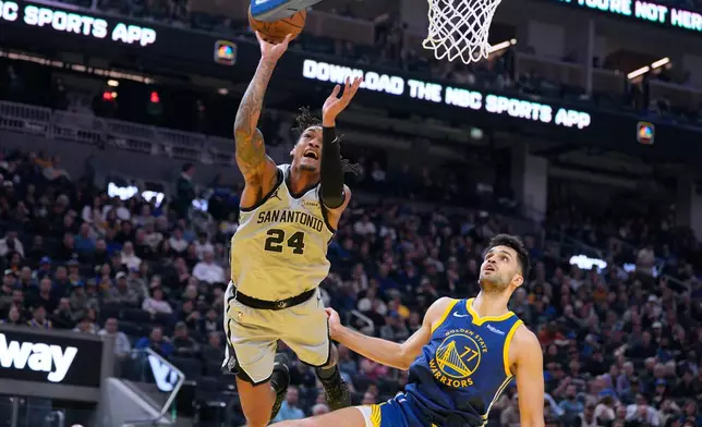 San Antonio Spurs guard Devin Vassell (24) reacts as he is fouled by Golden State Warriors center Omer Yurtseven (77) during the first half of an NBA basketball game in San Francisco, Wednesday, April 1, 2026. (AP Photo/Tony Avelar)