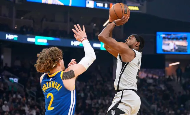 San Antonio Spurs guard De'aaron Fox (4) shoots over Golden State Warriors guard Brandin Podziemski (2) during the first half of an NBA basketball game in San Francisco, Wednesday, April 1, 2026. (AP Photo/Tony Avelar)