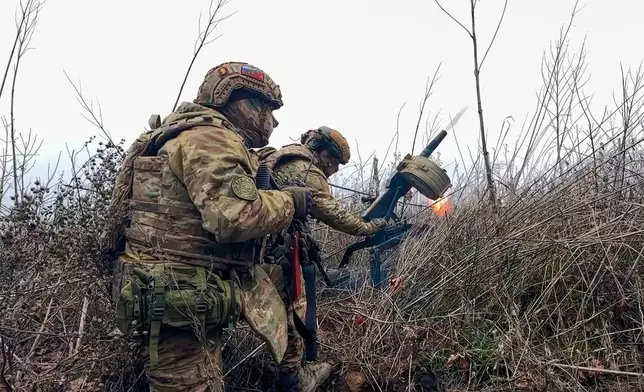 In this image made from video provided by Russian Defense Ministry Press Service on Tuesday, March 31, 2026, Russian soldiers fire a grenade launcher towards Ukrainian positions on an undisclosed location in Ukraine. (Russian Defense Ministry Press Service via AP)