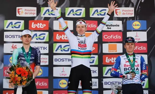 First place, Slovenia's Tadej Pogacar of the UAE Team Emirates, center, poses on the podium with second place France's Paul Seixas, left, and third place Belgium's Remco Evenepoel of the Red Bull Bora Hansgrohe team during the Belgian cycling classic and UCI World Tour race Liege Bastogne Liege, in Liege, Belgium, Sunday, April 26, 2026. (AP Photo/Geert Vanden Wijngaert)