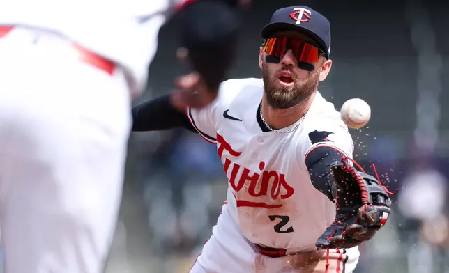 Minnesota Twins second baseman Kody Clemens flips the ball to first base to get the out on Detroit Tigers' Zach McKinstry during the fourth inning of baseball game, Thursday, April 9, 2026, in Minneapolis. (AP Photo/Matt Krohn)