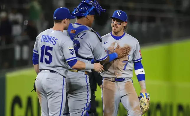 Kansas City Royals' Bobby Witt Jr. (7) and Salvador Perez, middle, celebrate the Royals victory over the Athletics in a baseball game Tuesday, April 28, 2026, in West Sacramento, Calif. (AP Photo/Scott Marshall)