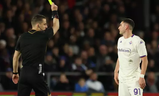 Fiorentina's Roberto Piccoli receives a yellow card during the Europa Conference League first-leg quarter-final soccer match between Crystal Palace and Fiorentina in London, Thursday, April 9, 2026. (AP Photo/Ian Walton)