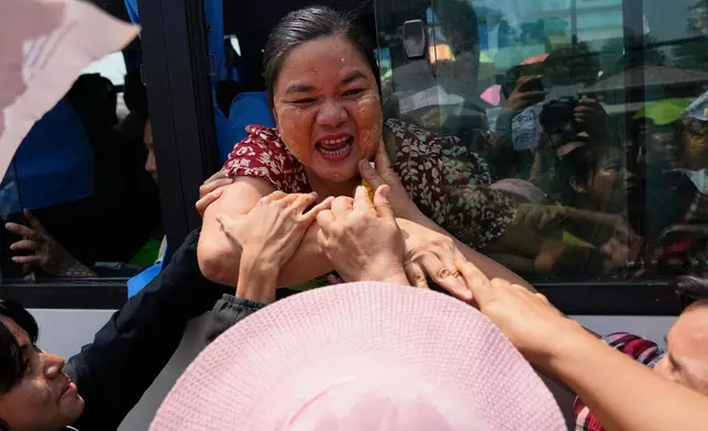 Released prisoners, in a bus, are welcomed by family members and colleagues after they left Insein Prison in Yangon, Myanmar, Friday, April 17, 2026, following Myanmar President's amnesty to mark the country's traditional new year. (AP Photo/Thein Zaw)