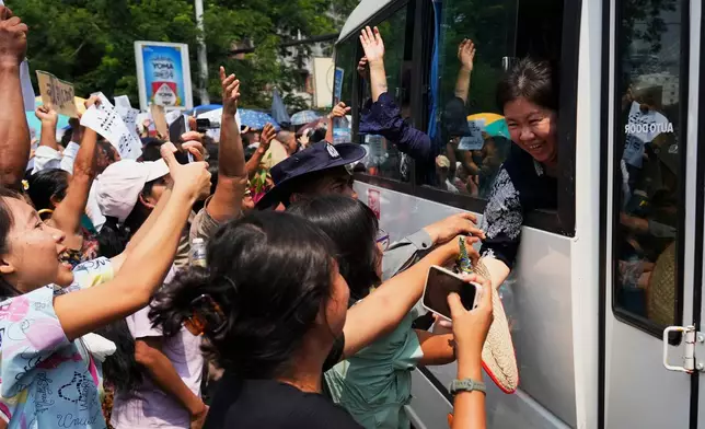 Released prisoners, in a bus, are welcomed by family members and colleagues after they left Insein Prison in Yangon, Myanmar, Friday, April 17, 2026, following Myanmar President's amnesty to mark the country's traditional new year. (AP Photo/Thein Zaw)