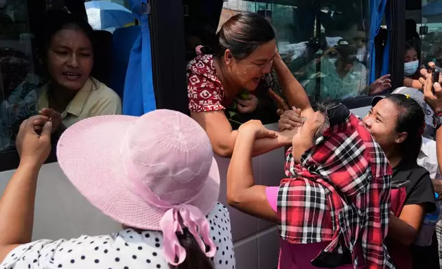 Released prisoners, in a bus, are welcomed by family members and colleagues after they left Insein Prison in Yangon, Myanmar, Friday, April 17, 2026, following Myanmar President's amnesty to mark the country's traditional new year. (AP Photo/Thein Zaw)