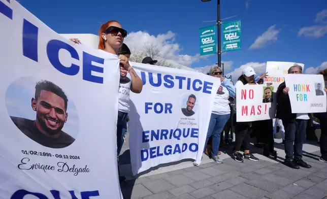 FILE - People display signs with with a likeness of Massachusetts State Police recruit Enrique Delgado-Garcia, who died following a State Police Academy training exercise, at a protest outside the State Police Academy graduation ceremony, Oct. 9, 2024, at the DCU Center, in Worcester, Mass. (AP Photo/Steven Senne, File)