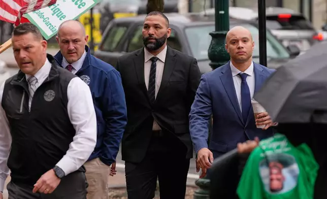 Mass State Police Trooper Edwin Rodriguez, center, arrives for arraignment on charges of involuntary manslaughter outside Worcester County Superior Court, Thursday, April 2, 2026, in Worcester, Mass. (AP Photo/Charles Krupa)