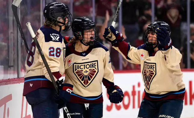 Montreal Victoire's Kaitlin Willoughby, center, celebrates after her goal against the Ottawa Charge with Catherine Dubois (28) and Alexandra Labelle, right, during second-period PWHL hockey game action in Ottawa, Ontario, Friday, April 3, 2026. (Justin Tang/The Canadian Press via AP)