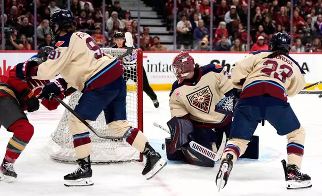 The puck rolls through the crease of Montreal Victoire goaltender Sandra Abstreiter, second from right, off a shot by Ottawa Charge's Gabbie Hughes, left, during third-period PWHL hockey game action in Ottawa, Ontario, Friday, April 3, 2026. (Justin Tang/The Canadian Press via AP)