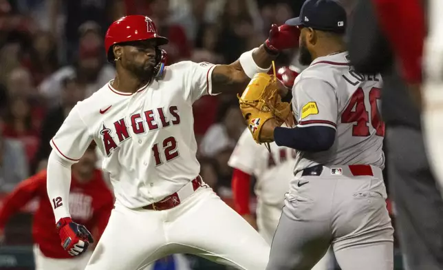 Los Angeles Angels' Jorge Soler (12) and Atlanta Braves' Reynaldo López (40) fight during the fifth inning of a baseball game, Tuesday, April 7, 2026, in Anaheim, Calif. (AP Photo/Ethan Swope)