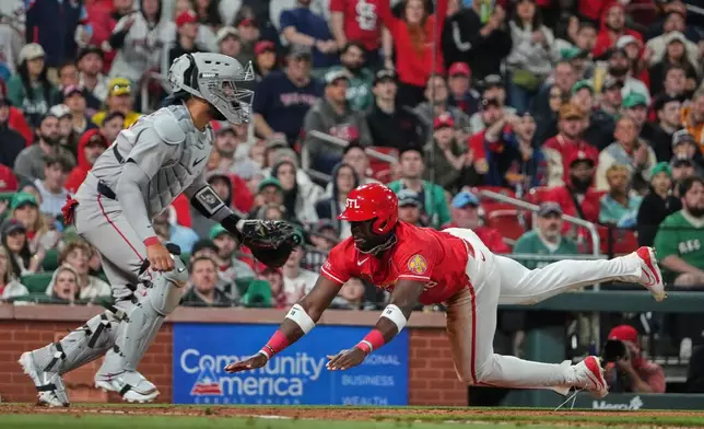 St. Louis Cardinals' Jordan Walker, right, scores past Boston Red Sox catcher Carlos Narvaez during the fifth inning of a baseball game Friday, April 10, 2026, in St. Louis. (AP Photo/Jeff Roberson)