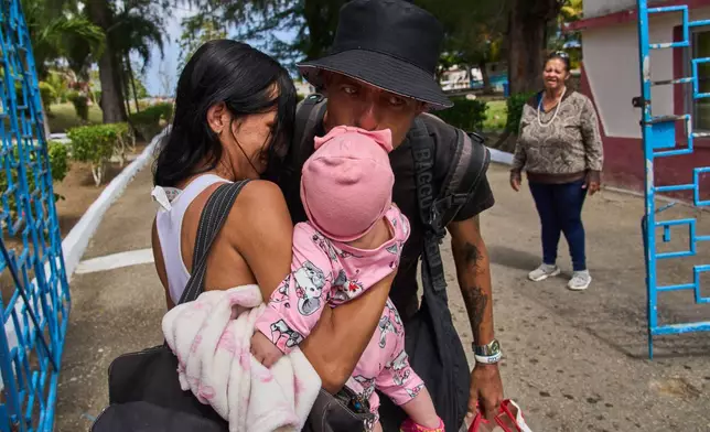 A pardoned prisoner kisses his daughter after leaving La Lima penitentiary in Guanabo, Cuba, Friday, April 3, 2026. (AP Photo/Ramon Espinosa)