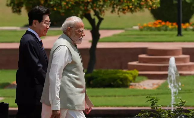 India Prime Minister Narendra Modi and South Korean President Lee Jae Myung walk to plant sampling of an Ashoka tree in New Delhi, India, Monday, April 20, 2026. (AP Photo/Manish Swarup)