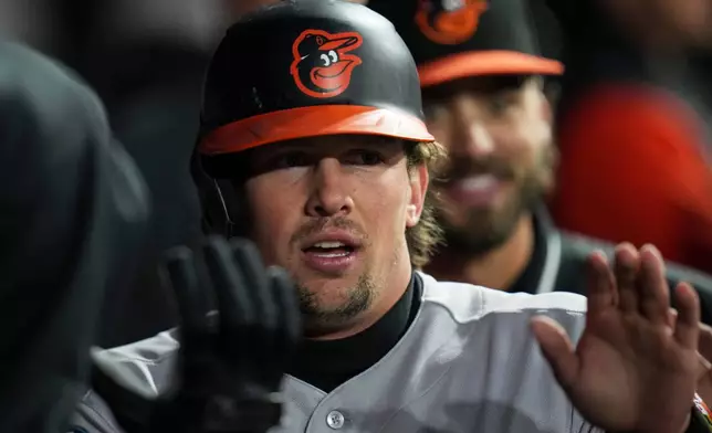Baltimore Orioles' Adley Rutschman (35) celebrates after scoring on a single from Tyler O'Neill (9) during the fourth inning of a baseball game against the Chicago White Sox, Monday, April 6, 2026, in Chicago. (AP Photo/Erin Hooley)