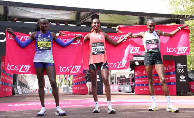 Winner Tigst Assefa of Ethiopia, center, second placed Hellen Obiri of Kenya, right and third placed Joyceline Jepkosgei of Kenya celebrate after the women's race at the London Marathon in London, Sunday, April 26, 2026.(AP Photo/Ian Walton)