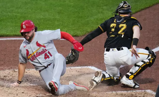 St. Louis Cardinals' Alec Burleson (41) slides safely past the tag attempt by Pittsburgh Pirates catcher Henry Davis, scoring on a sacrifice fly by Nolan Gorman off Pirates pitcher Hunter Barco during the fifth inning of a baseball game in Pittsburgh, Thursday, April 28, 2026. (AP Photo/Gene J. Puskar)