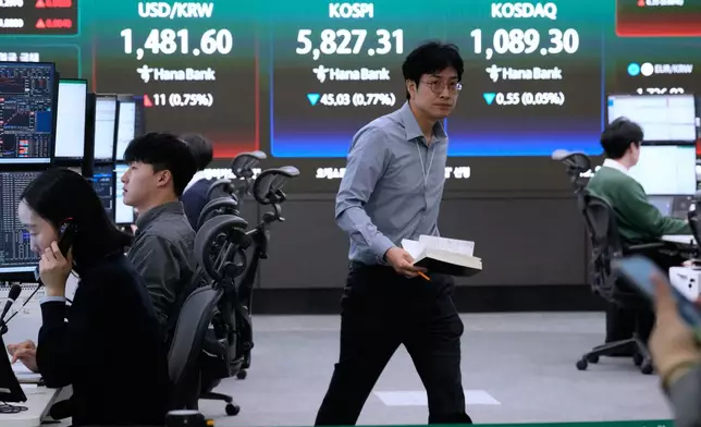 Currency traders work near a screen showing the Korea Composite Stock Price Index (KOSPI), top center, and the foreign exchange rate between U.S. dollar and South Korean won, top center left, at the foreign exchange dealing room of the Hana Bank headquarters in Seoul, South Korea, Thursday, April 9, 2026. (AP Photo/Ahn Young-joon)