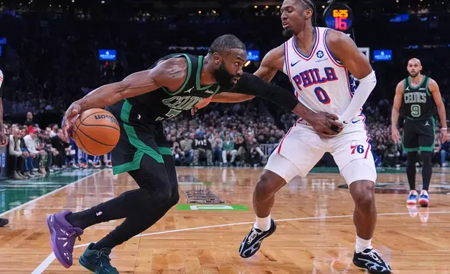 Boston Celtics guard Jaylen Brown, left, drives to the basket against Philadelphia 76ers guard Tyrese Maxey (0) during the first half of Game 5 of a first-round NBA playoffs basketball series, Tuesday, April 28, 2026, in Boston. (AP Photo/Charles Krupa)