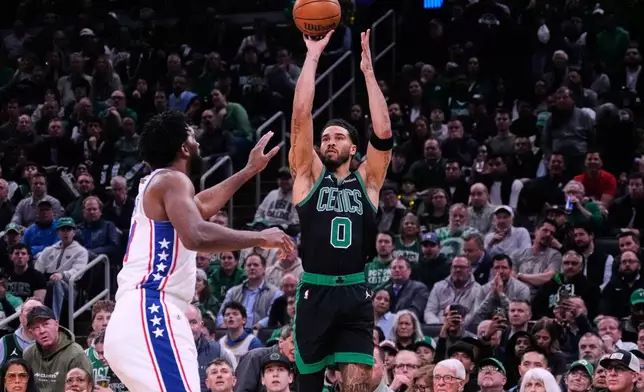 Boston Celtics forward Jayson Tatum (0) takes a 3-point shot over Philadelphia 76ers center Joel Embiid, left, during the first half of Game 5 of a first-round NBA playoffs basketball series, Tuesday, April 28, 2026, in Boston. (AP Photo/Charles Krupa)